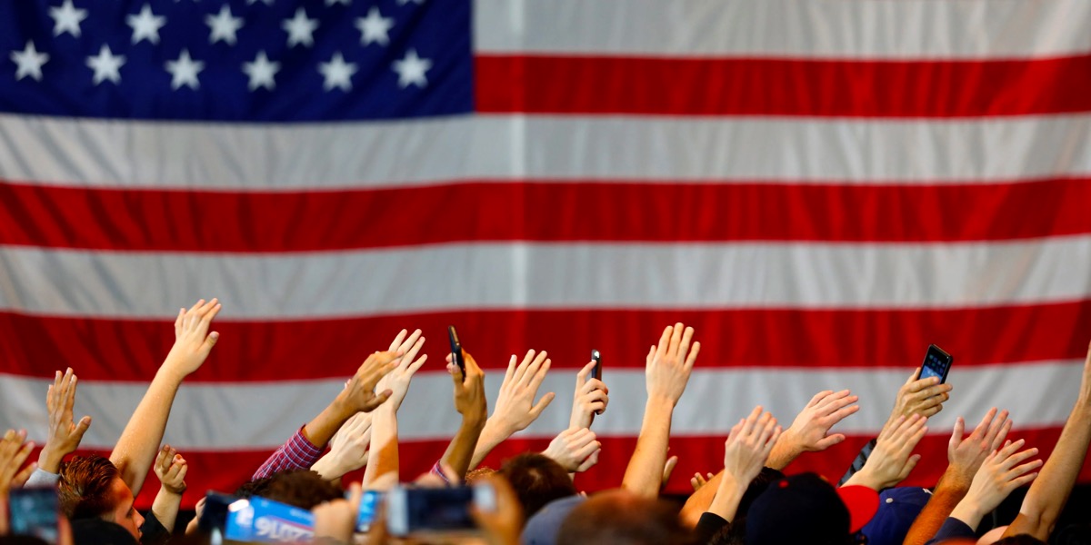 United States Flag with people raising their hands
